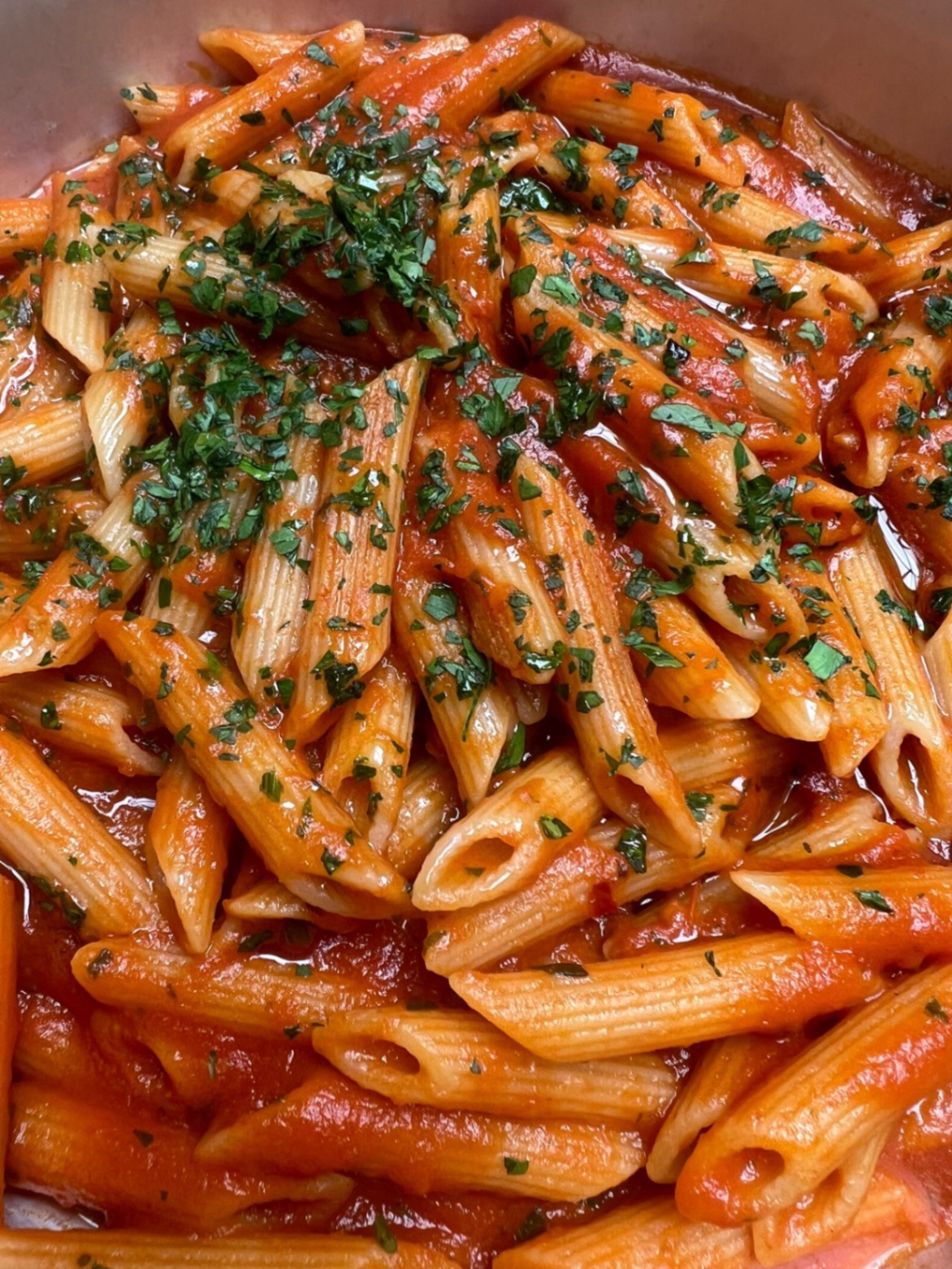 Freshly cooked penne in tomato sauce, finished with chopped parsley in the pan
